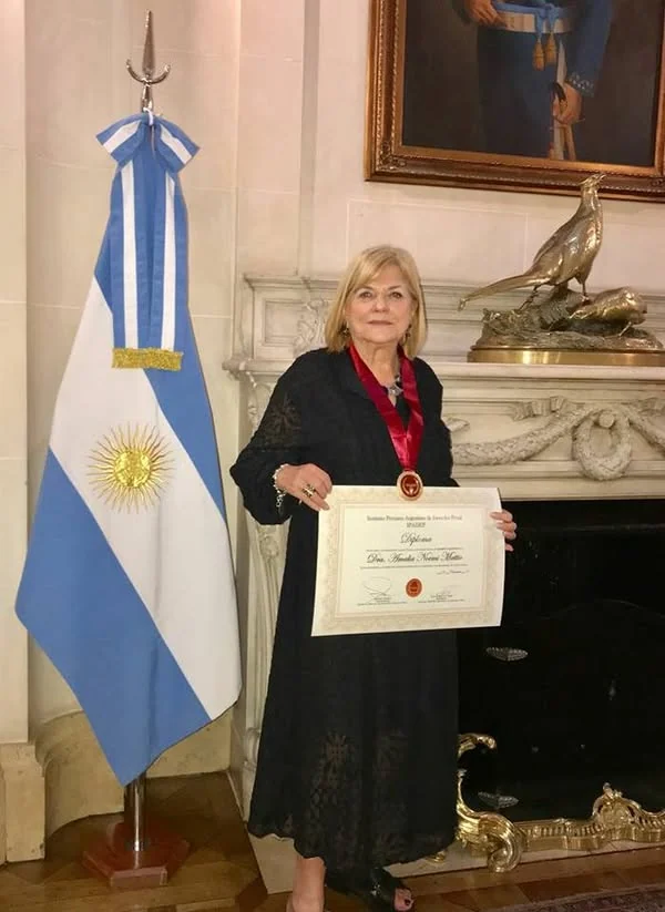Una integrante distinguida muestra su diploma y medalla en la ceremonia de la Cancillería argentina.