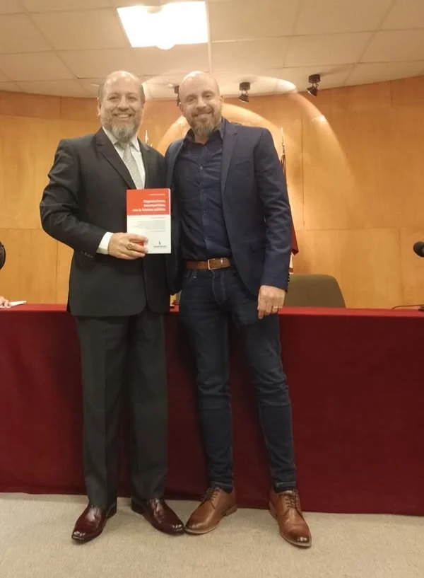 Fotografía de los participantes con un libro de la editorial Hammurabi.