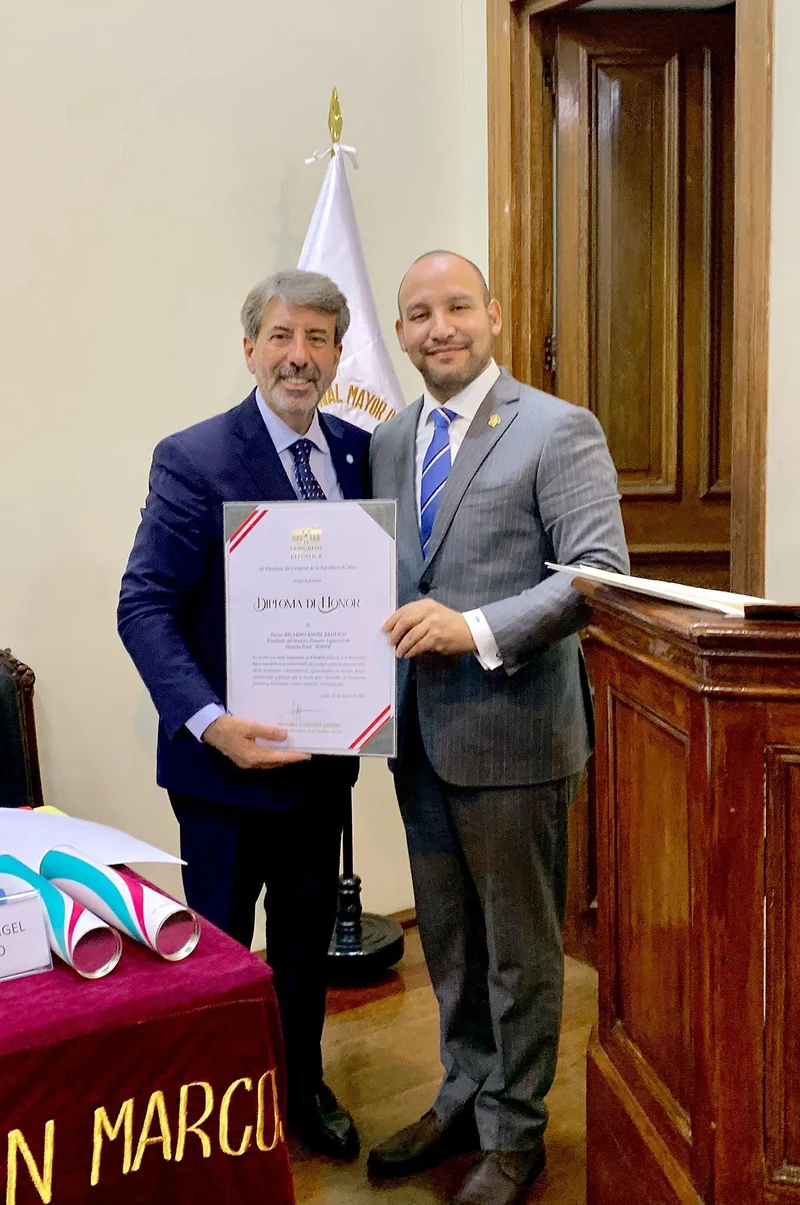 Entrega de un diploma de honor durante un congreso académico.