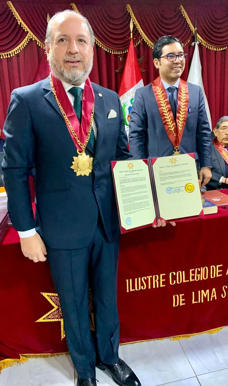 Miembro incorporado muestra el diploma y la insignia recibidos en la ceremonia del Colegio de Abogados de Lima.