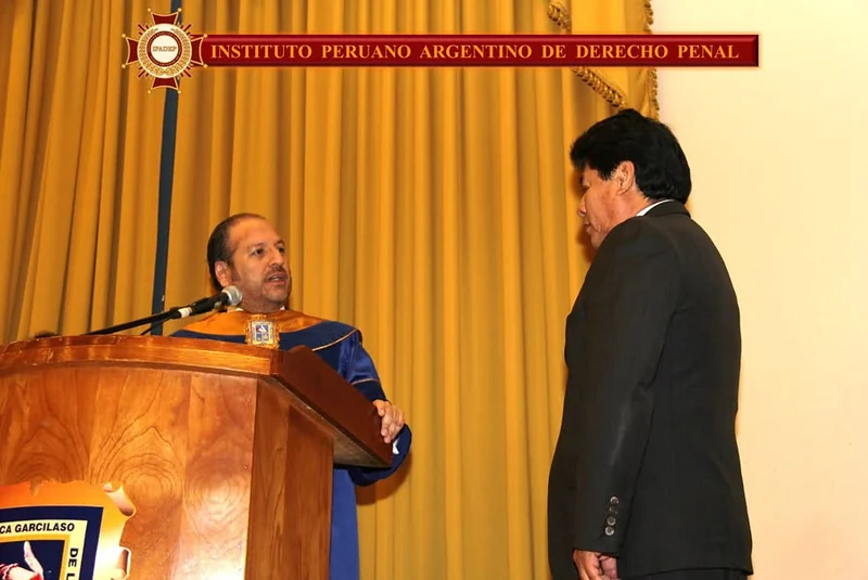 Entrega de una distinción ante el atril de la ceremonia de incorporación en la UIGV.