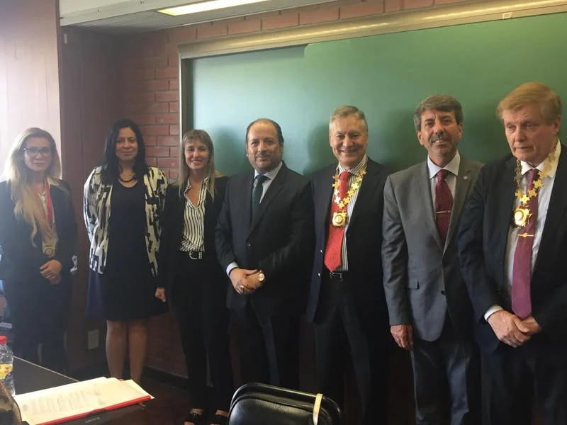 Fotografía de los representantes y distinguidos, con sus medallas, en el aula de la Universidad de Belgrano.