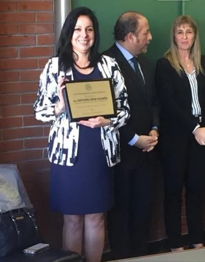 Una participante muestra la placa recibida durante la ceremonia en la Universidad de Belgrano.