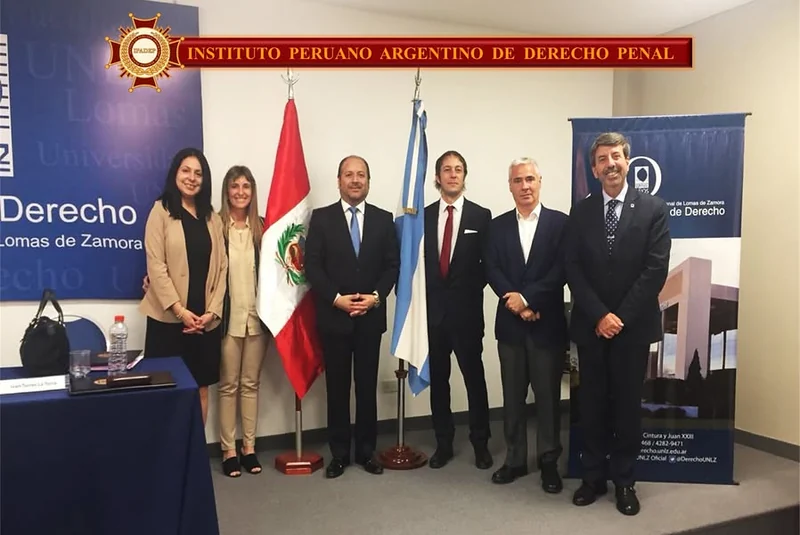 Representantes y participantes de la jornada académica, ante las banderas y el panel de la Universidad Nacional de Lomas de Zamora.