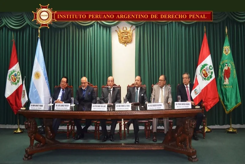 Mesa de honor de la presentación e incorporación de miembros del IPADEP en San Marcos, flanqueada por las banderas institucionales.