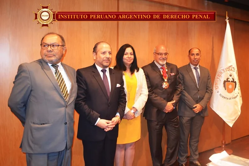 Fotografía de los participantes en la conferencia sobre corrupción de funcionarios, junto al estandarte de la Universidad de Lima.
