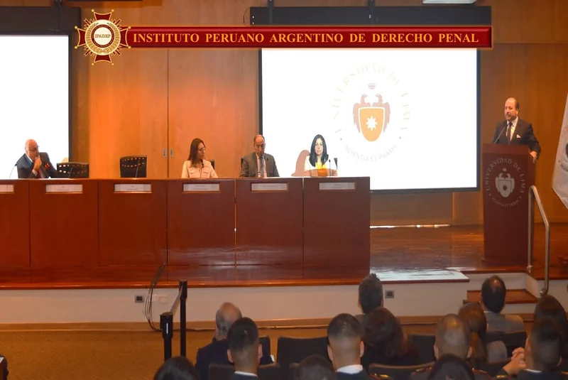 Intervención desde el atril ante la mesa de expositores y el público de la Universidad de Lima.