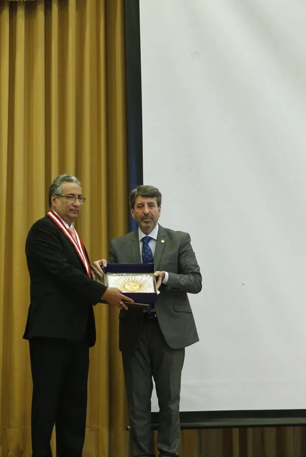 Dos participantes muestran una placa de reconocimiento durante el congreso de la UIGV.