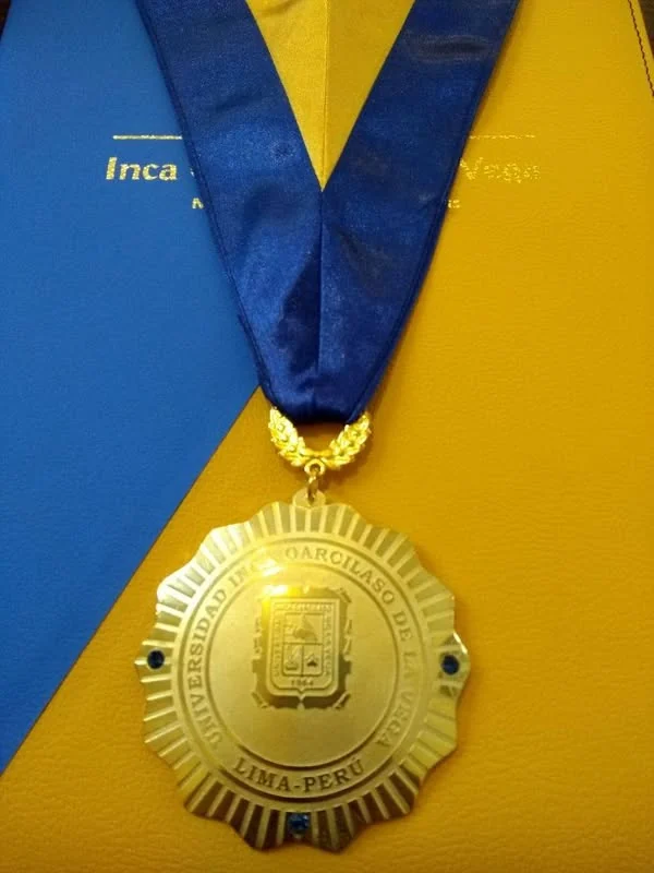 Detalle de la medalla de la Universidad Inca Garcilaso de la Vega, con cinta azul.