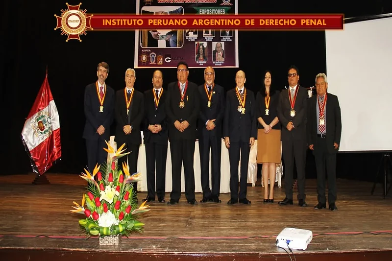 Grupo de distinguidos con sus medallas sobre el escenario de la conferencia de Tacna.